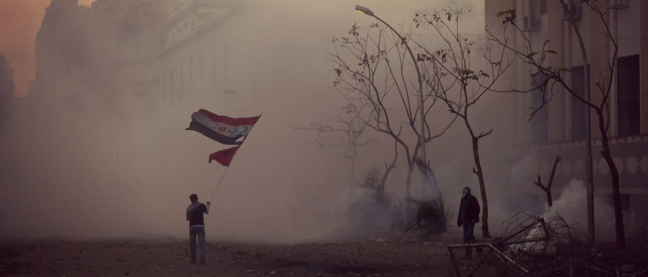En 2012 en Égypte, ce manifestant brandissait le drapeau du pays ainsi que les emblèmes de l'islam et de la chrétienté, symbole de paix et d'œcuménisme. Crédit Alisdare Hickson.