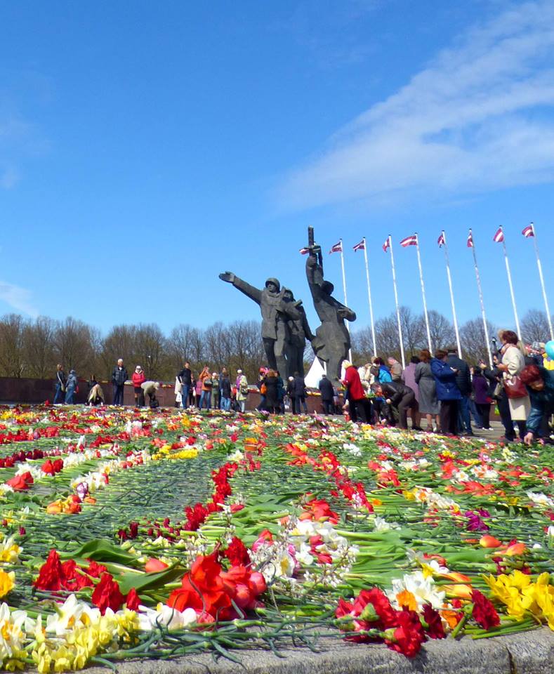 Au pied de la statut des libérateurs, on dépose des fleurs en hommage aux soldats tombés au combat. Crédit Elisa Maziere.