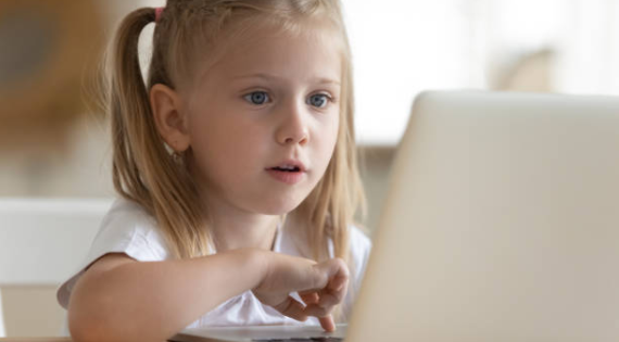 Petite fille regardant un écran d'ordinateur ; Photo par @fizkes